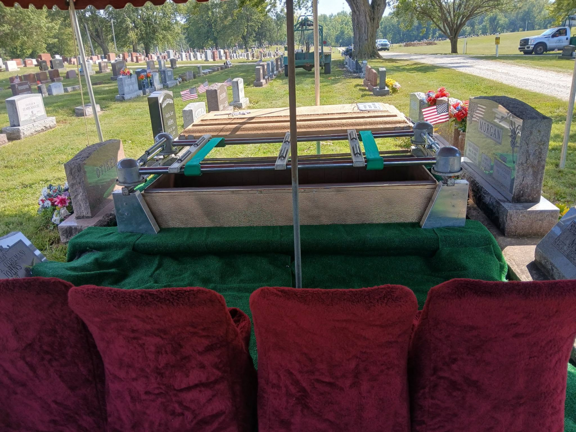 Graveside tent setup with seating, lowering device and burial vault in Logansport, IN