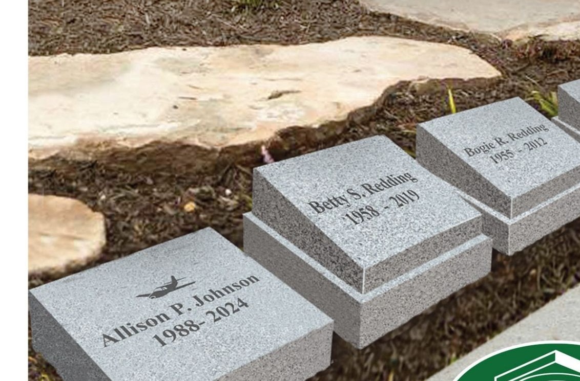 Engraved granite memorial markers set along a cemetery garden path
